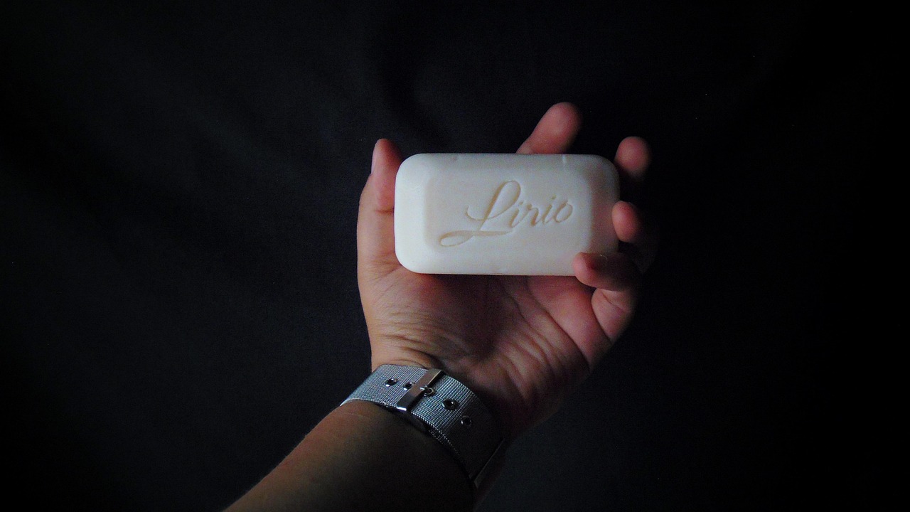 Donna con capelli voluminosi e lucenti, sorride mentre tiene in mano il prodotto Trico Rosmarinus.