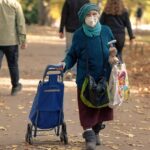 Anziano sorridente che consulta un documento su un tavolo, simbolo del bonus anziani 2025.