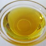 Olio d'oliva torbido in un contenitore, segnale di deterioramento e necessità di sostituzione.